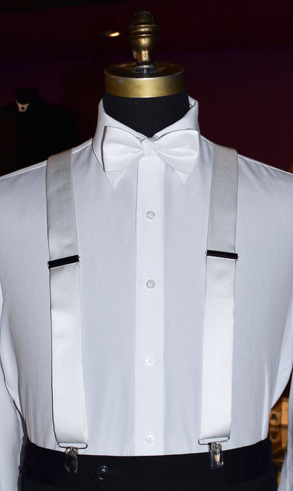 white satin suspenders and bowtie on a mannequin at a tuxedo shop