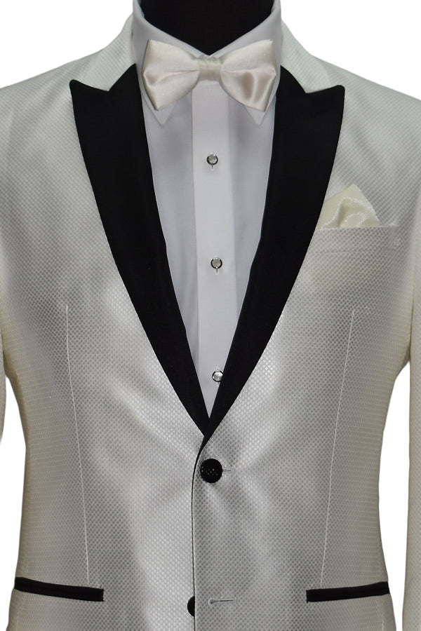 close-up life size mannequin wearing a winter white tuxedo with black lapels wearing an ivory satin bowtie,  mother-of-pearl studs and cufflinks and black tuxedo pants on a mannequin against a white background