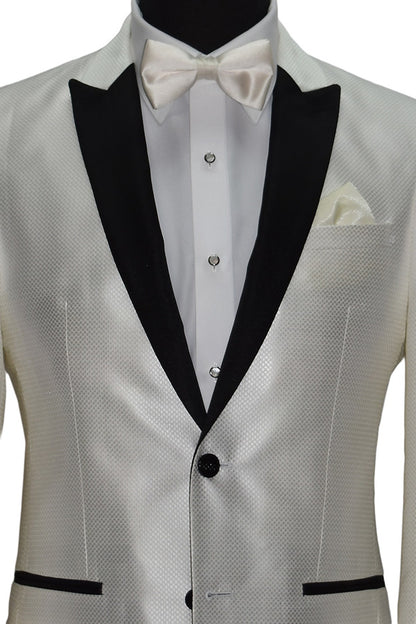 close-up life size mannequin wearing a winter white tuxedo with black lapels wearing an ivory satin bowtie,  mother-of-pearl studs and cufflinks and black tuxedo pants on a mannequin against a white background
