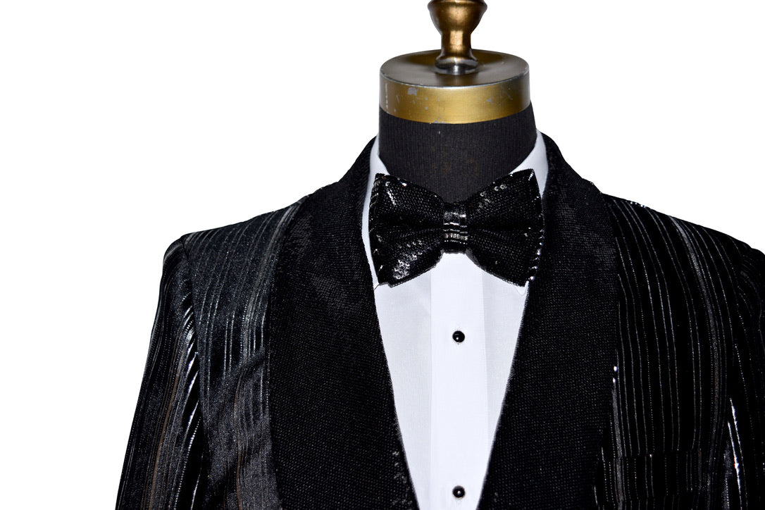 Black and silver sequins shawl collar tuxedo with a bow tie on a mannequin against a white background