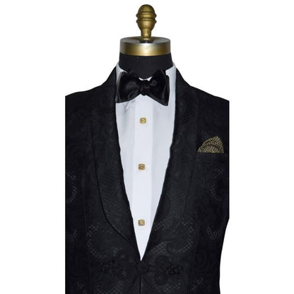 very close up mannequin wearing Black shawl collar dinner jacket with brocade pattern shown with white tuxedo shirt and black bow tie on a white background
