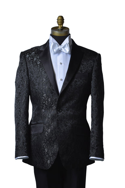 Black brocade tuxedo wearing a white shirt and white satin bow tie on a mannequin against a white background