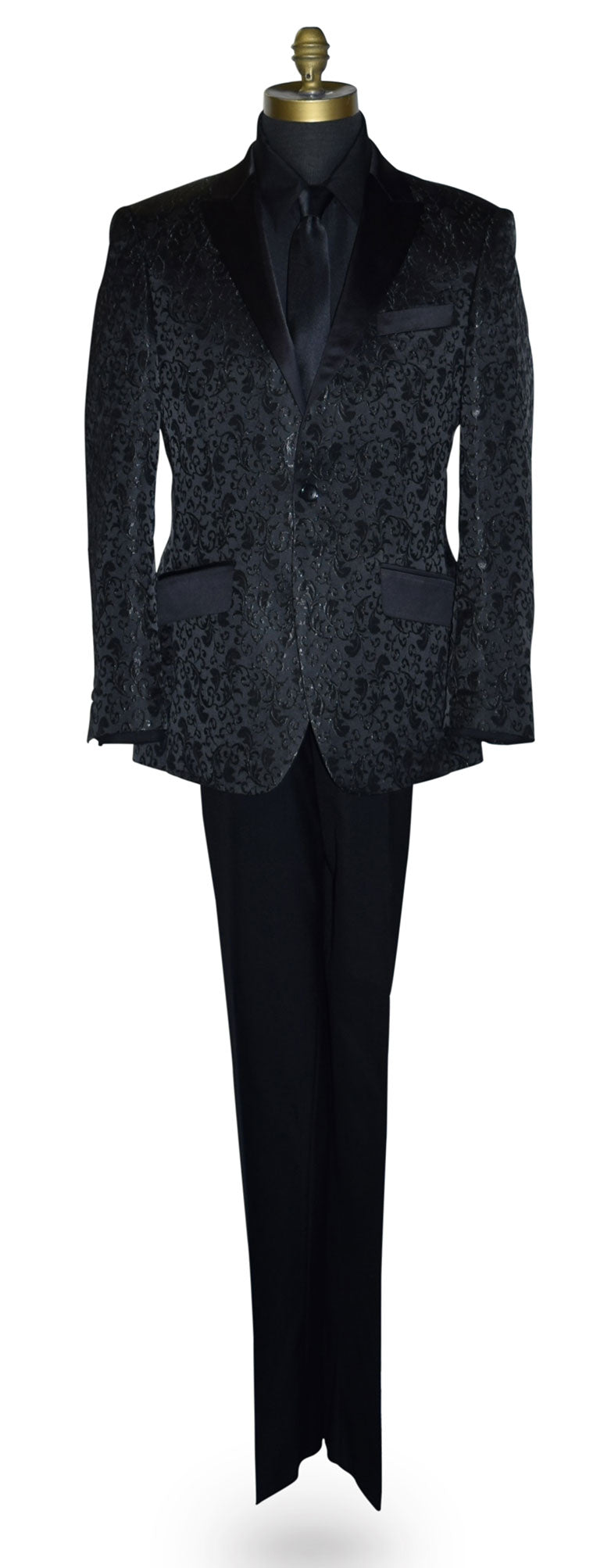 Black brocade tuxedo wearing a black shirt and long black necktie on a mannequin against a white background