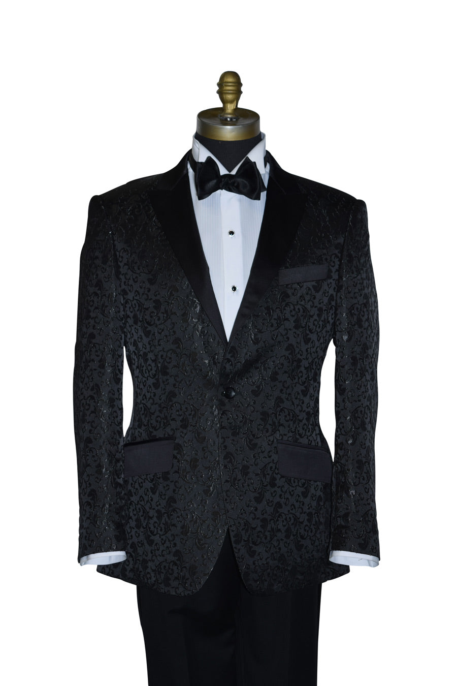 Black brocade tuxedo wearing a white shirt and black bow tie on a mannequin against a white background