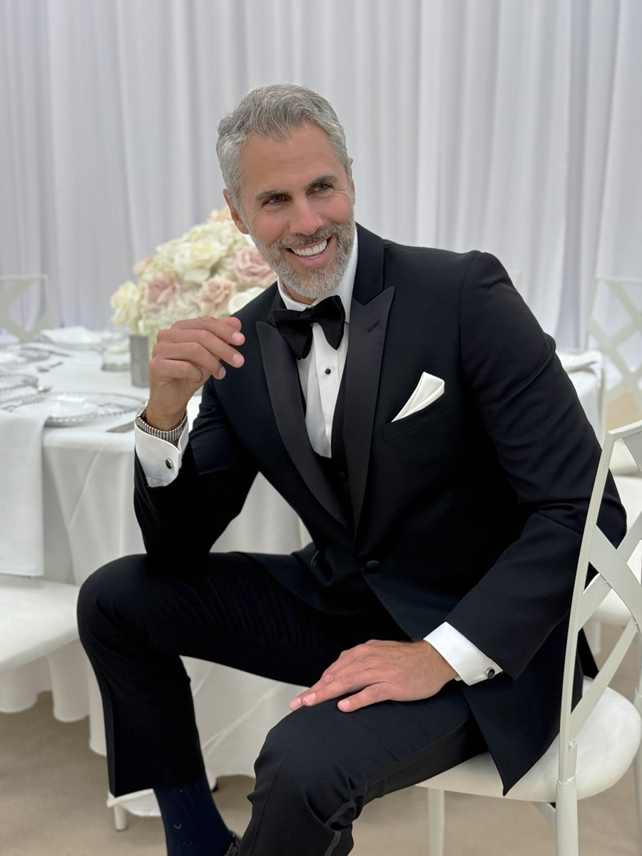 Man at reception wearing a black peak lapel tuxedo 