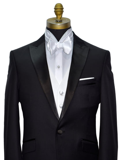 front view  black peak lapel tuxedo with a white wing collar tuxedo shirt and a white "tie-yourself" bowtie on a mannequin against a white background