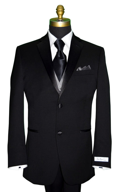 Mannequin wearing a black notch lapel tuxedo with a "San Miguel Especial" branded label with a gray vest and a black silk neck-tie against a white background