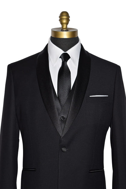 close-up black wedding tuxedo with a long black necktie and a black four-button tuxedo vest on a manneqin against a white background
