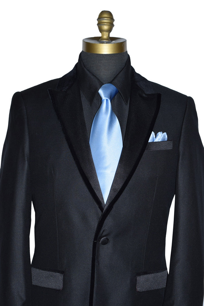 close-up black tuxedo with velvet trimm on lapel wearing a light blue necktie on a mannequin against a white background