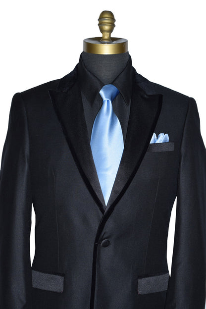 close-up black tuxedo with velvet trimm on lapel wearing a light blue necktie on a mannequin against a white background