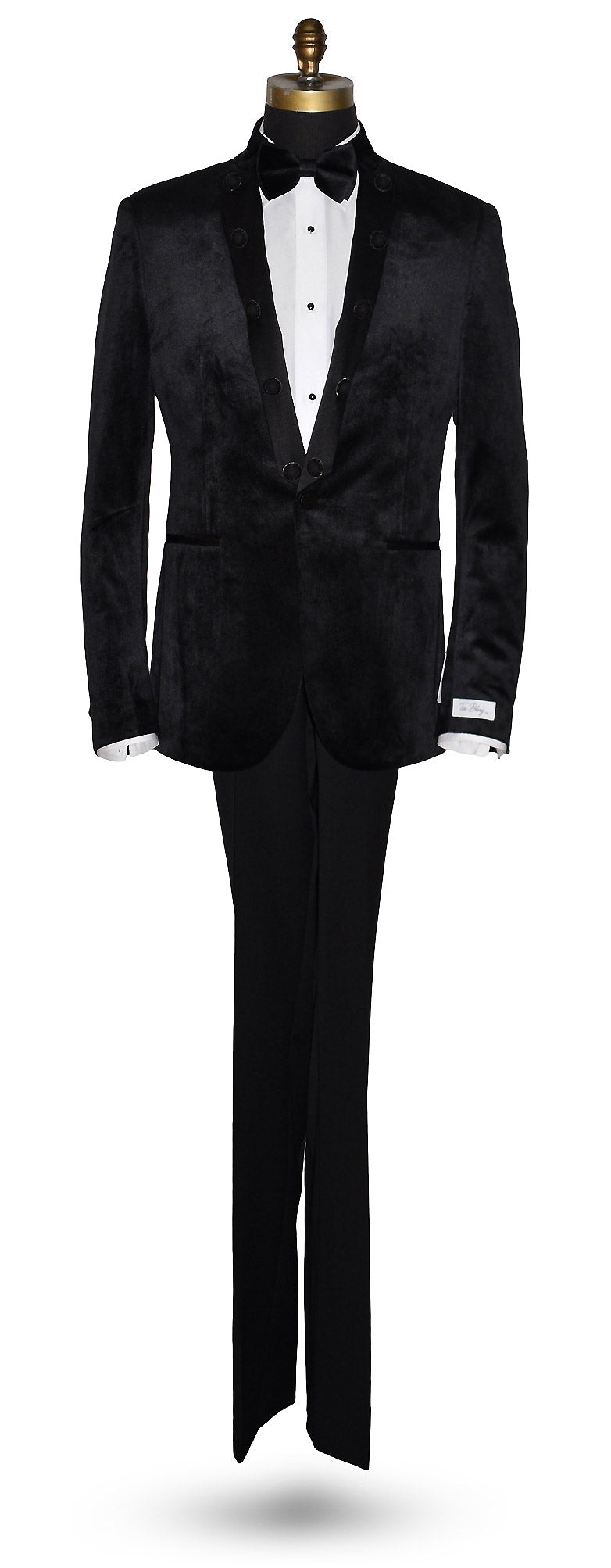life size mannequin black velvet nehru tuxedo jacket worn with a black bowtie and black tuxedo pants against a white background
