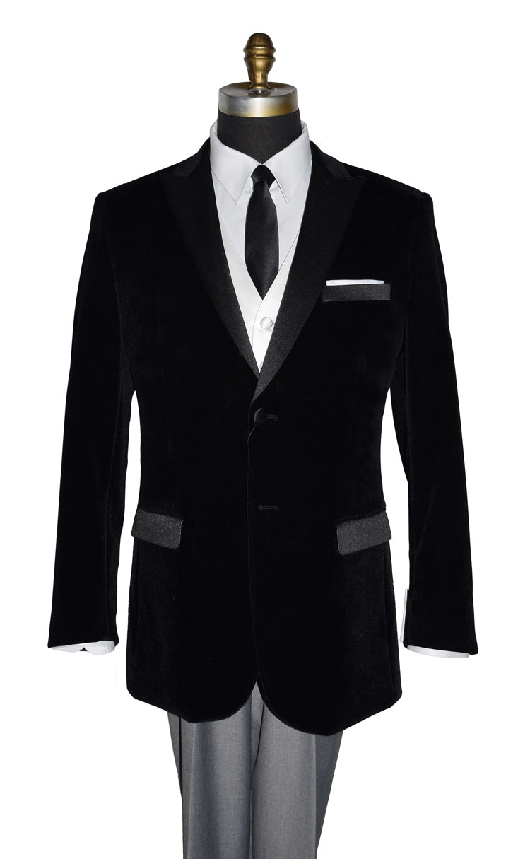 close-up mannequin wearing black velvet tuxedo with white shirt and gray pants and a skinny black satin necktie on a mannequin against a white background