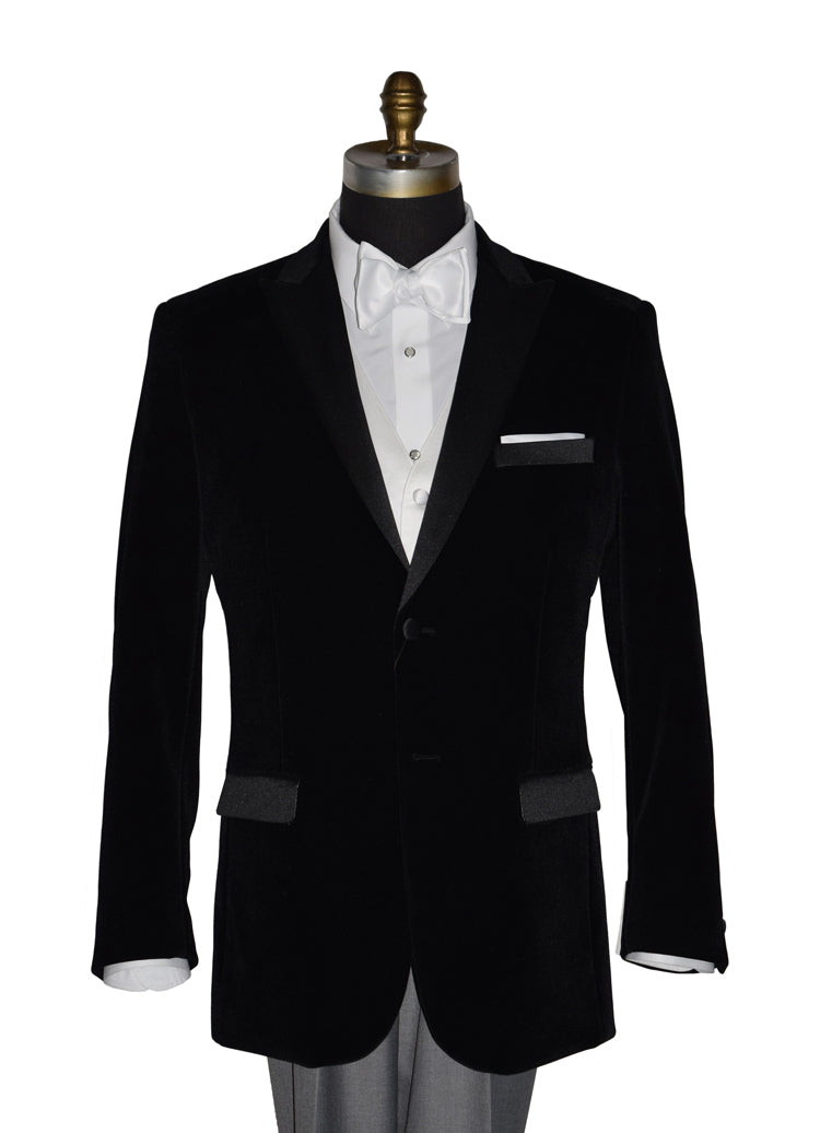 close-up black velvet tuxedo with white shirt and gray pants and a white satin bowtie on a mannequin against a white background