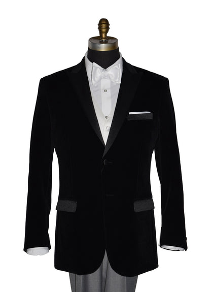 close-up black velvet tuxedo with white shirt and gray pants and a white satin bowtie on a mannequin against a white background