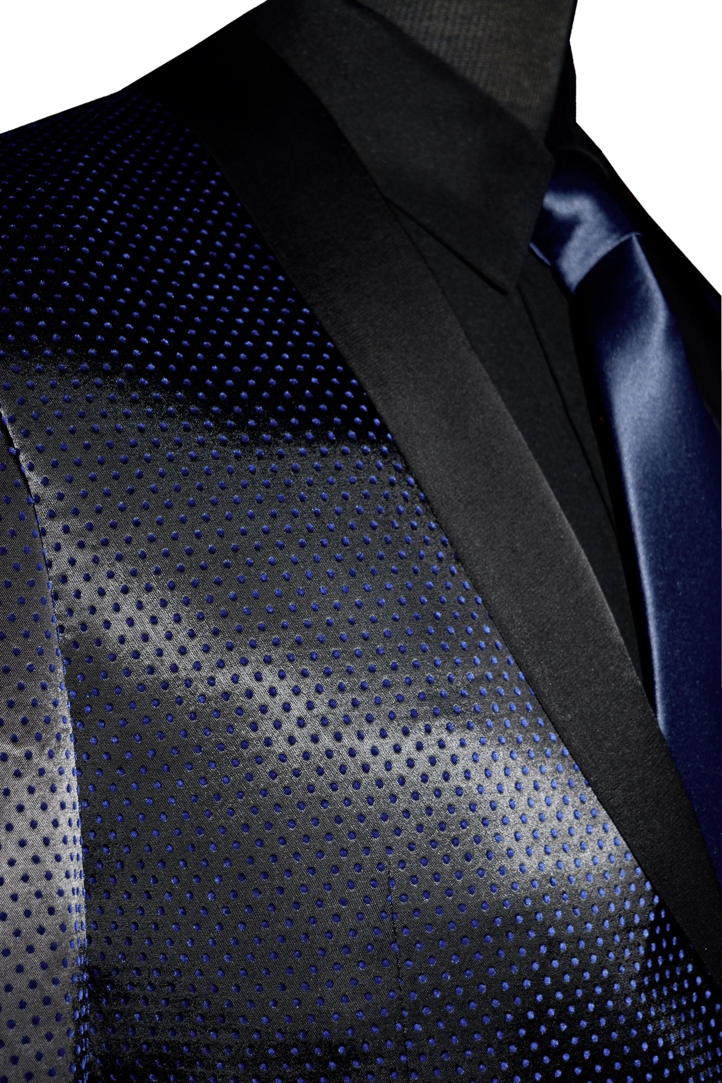 very close-up side view mannequin wearing a blue shawl collar tuxedo with a black tuxedo shirt and long blue necktie against a white background