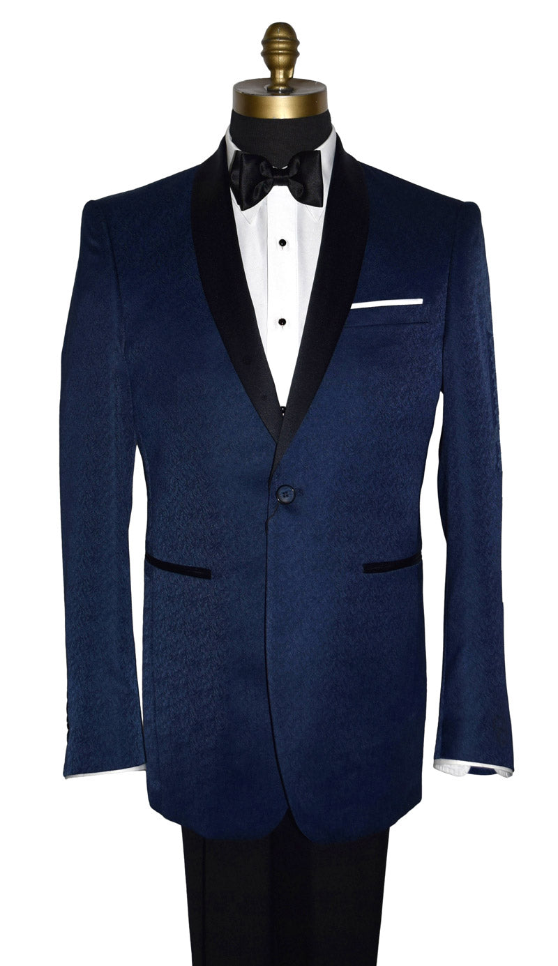 close-up Navy blue tuxedo with black shawl collar with a brocade print on a mannequin with black tuxedo pants and a white tuxedo shirt and black satin bowtie in front of a white background