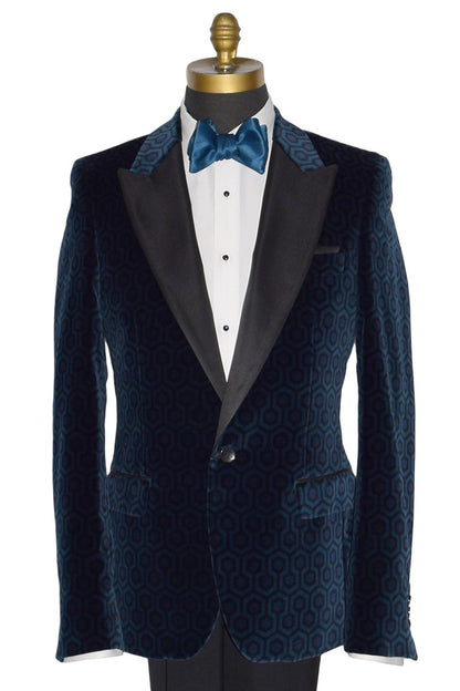 close-up life size mannequin wearing a blue velvet tuxedo jacket with a white tuxedo shirt and blue tie-yourself bowtie against a white background
