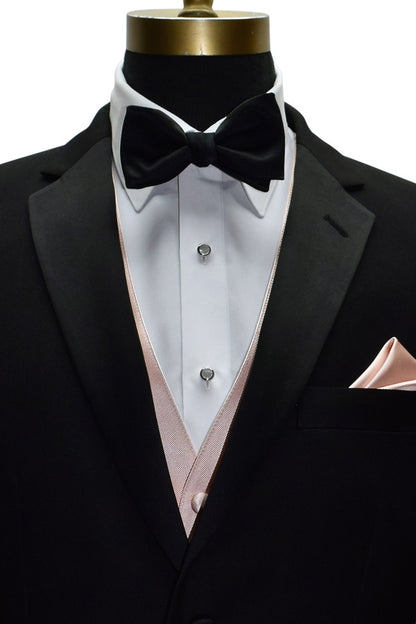 close-up Black tuxedo with white shirt, black bow tie, and blush vest and pocket handkerchief on a mannequin against a white background