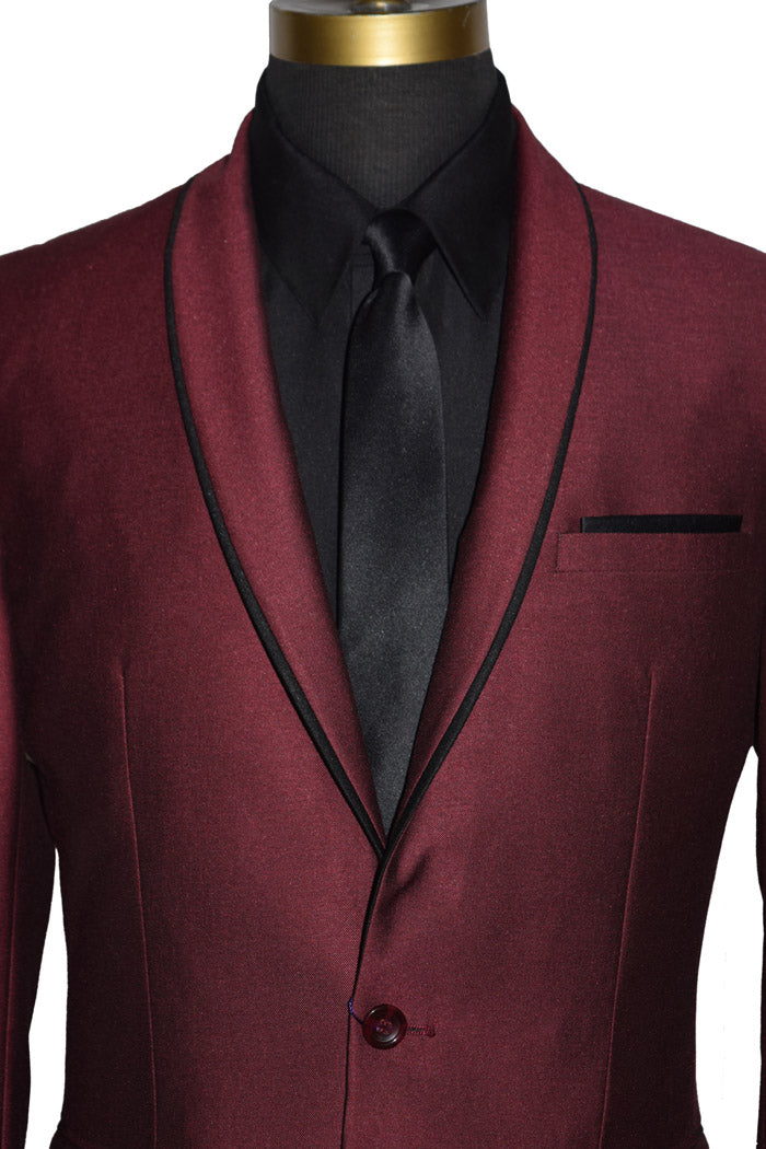 very close up mannequin wearing a burgundy shawl collar tuxedo with a black shirt and black skinny necktie on a mannequin against a white background