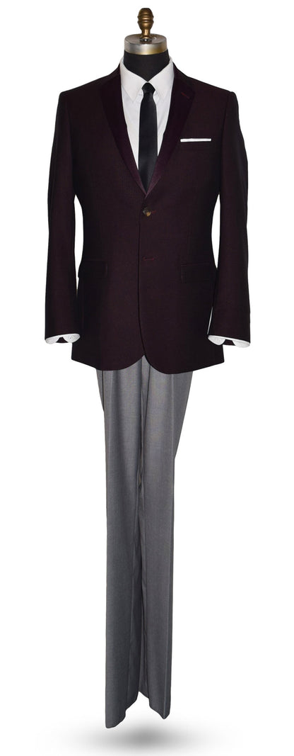 life size mannequin wearing a burgundy tuxedo jacket with a white tuxedo shirt and a long black skinny necktie against a white background