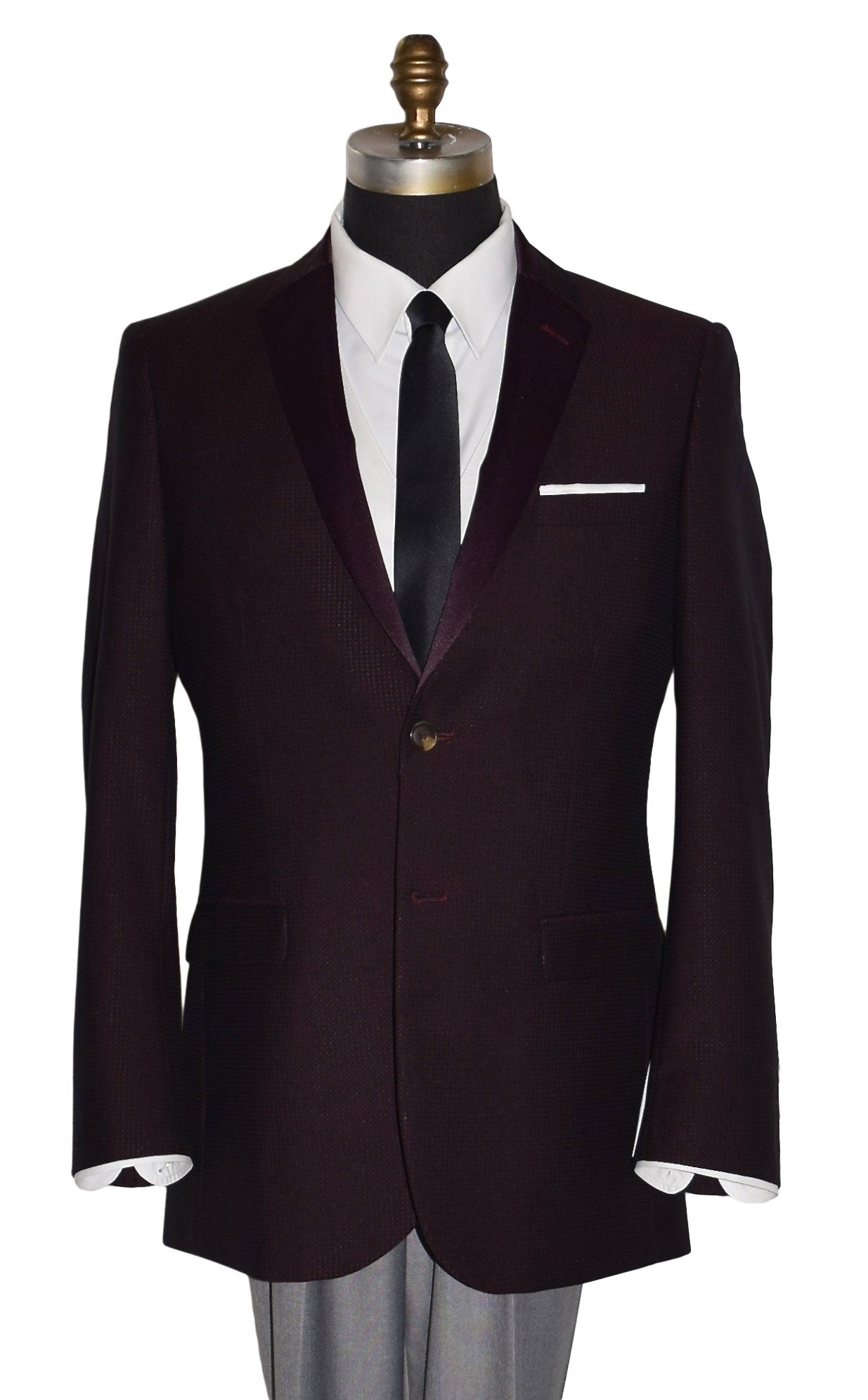 close-up  life size mannequin wearing a burgundy tuxedo jacket with a white tuxedo shirt and a long black skinny necktie against a white background