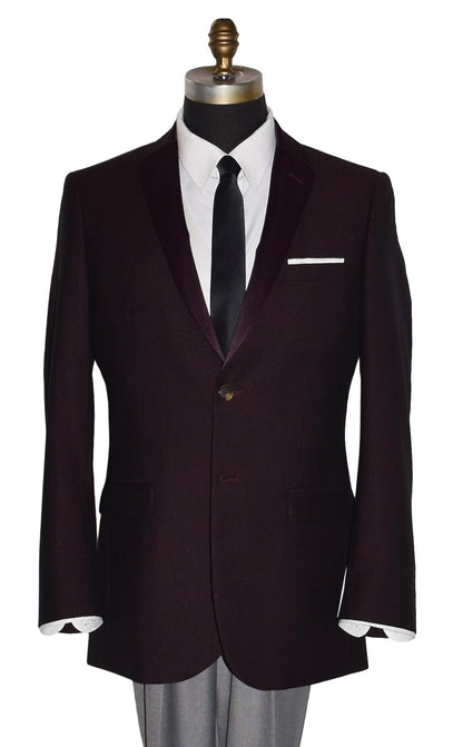 close-up  life size mannequin wearing a burgundy tuxedo jacket with a white tuxedo shirt and a long black skinny necktie against a white background