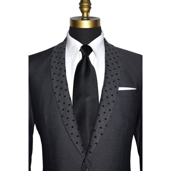 detailed view- mannequin wearing a charcoal gray dinner jacket with a white tuxedo shirt and black long neck-tie against a white background