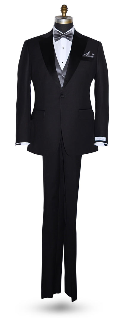 life size mannequin wearing a black notch-lapel tuxedo with a "San Miguel Especial" branded label with a charcoal tuxedo vest and charcoal pre-tied bowtie and pocket handkerchief against a white background