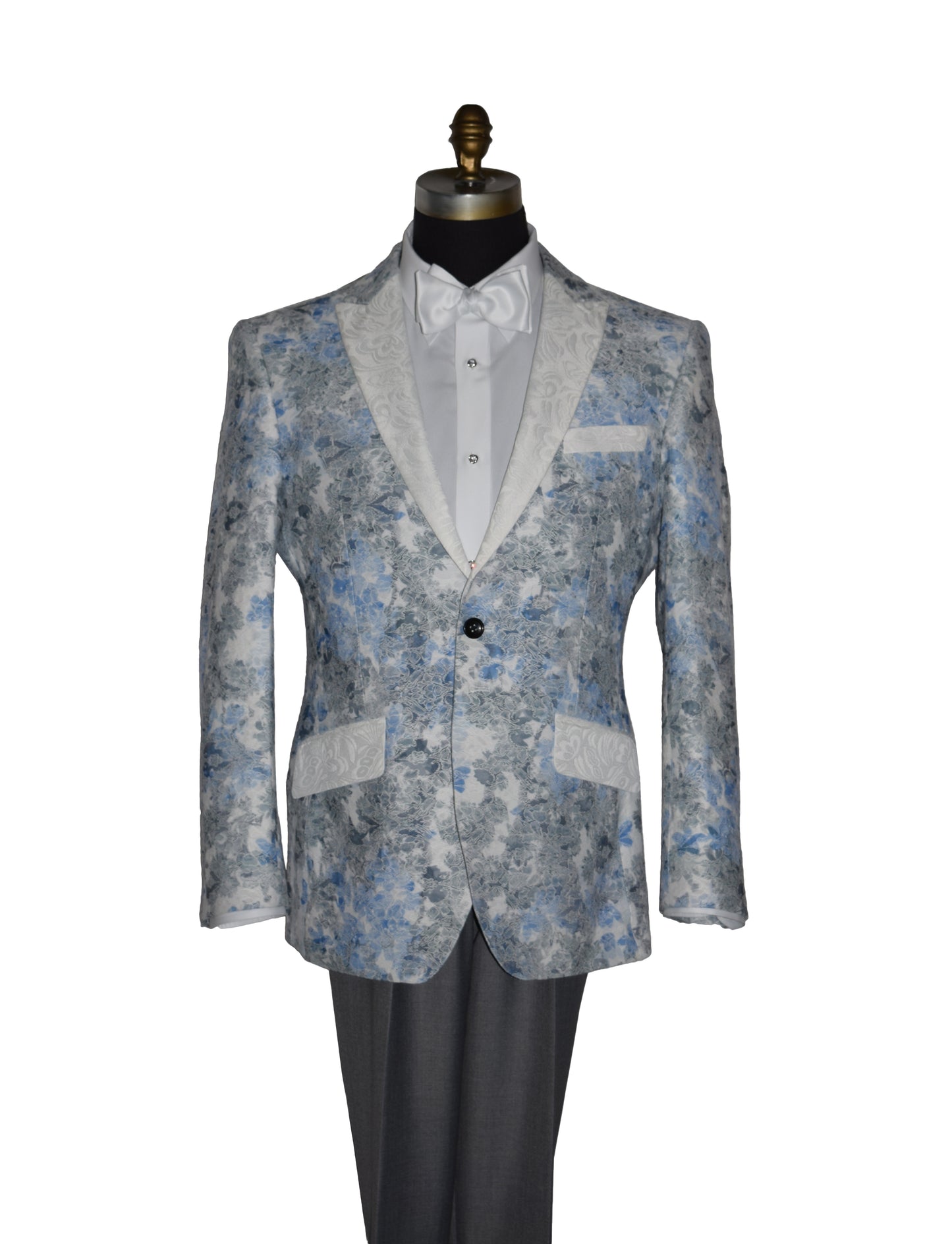 close-up blue and gray floral-patterned tuxedo jacket with a white bowtie and gray pants on a mannequin against a white background