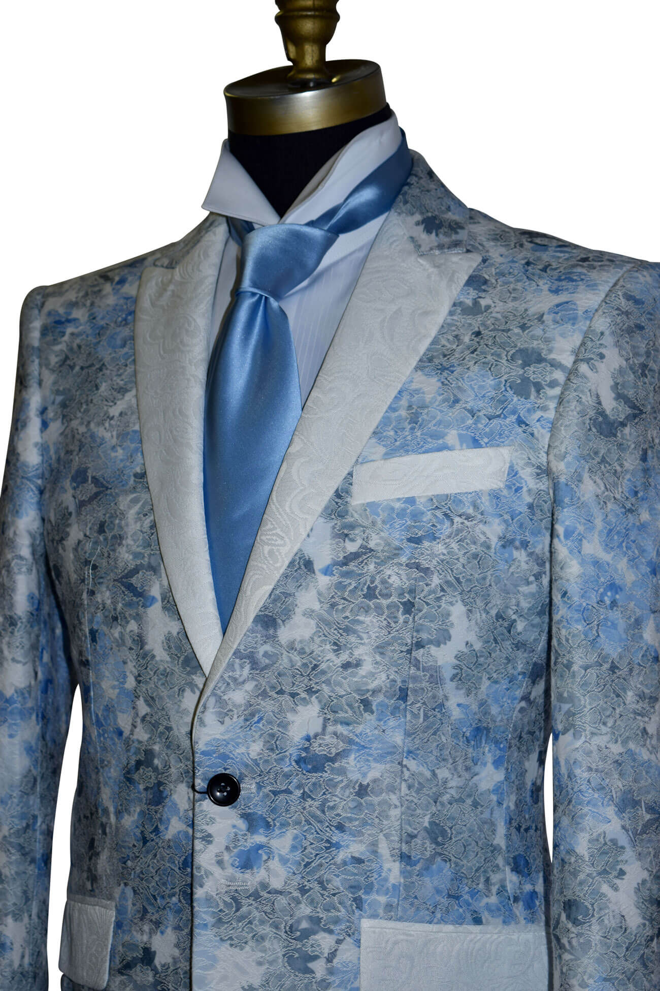 close-up Blue floral patterned tuxedo jacket on a mannequin with a long baby-blue necktie against a white background