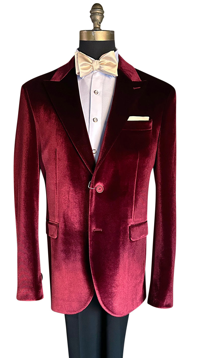 close up of crimson red Burgundy velvet dinner jacket on a mannequin with a white shirt and champagne bow tie.