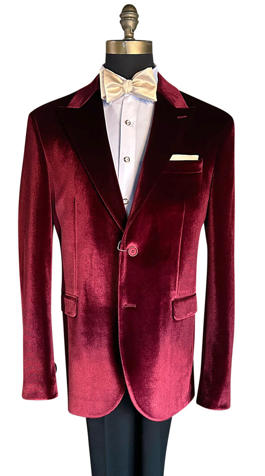 close up of crimson red Burgundy velvet dinner jacket on a mannequin with a white shirt and champagne bow tie.