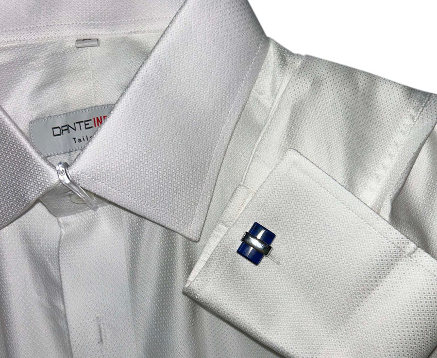 Close-up of a white dress shirt with blue and silver cufflinks on a Dante Inferno shirtl.