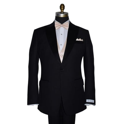 black tuxedo with nude pre-tied bowtie and nude color pocket handkerchief against a white background
