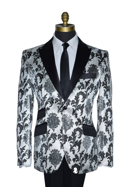 close up silver and black peak lapel tuxedo wearing a black dress tie against a white background