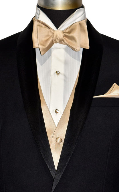 super close-up black shawl collar tuxedo with ivory tuxedo shirt and golden "tie-yourself" bowtie and a golden tuxedo vest against a white background