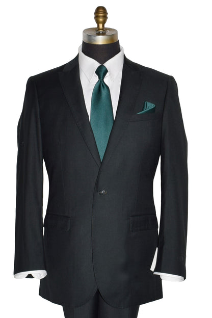 close-up mannequin wearing a men's hunter green suit coat and matching pants with a white dress shirt and green necktie in-front of a white background