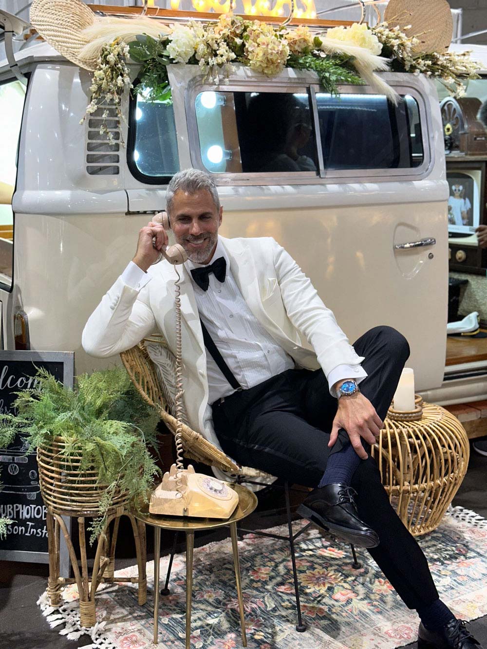man wearing an ivory peak lapel dinner jacket white talking on the phone