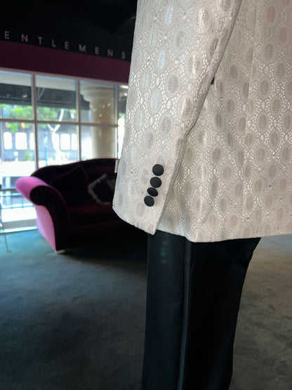 side view -ivory shawl collar tuxedo with black pants in a mens store