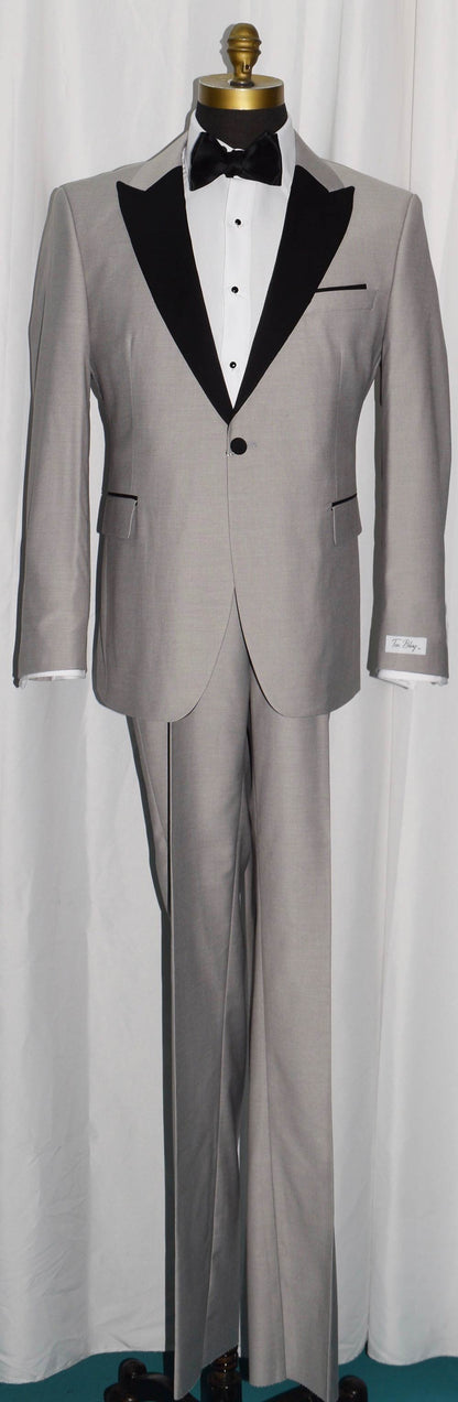 life size mannequin wearing light gray peak lapel tuxedo with black bow tie inside of a menswear shop