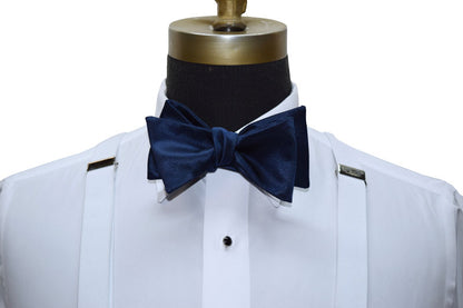 close-up mannequin wearing a white tuxedo shirt with a marine-blue tie-yourself bowtie against a white background