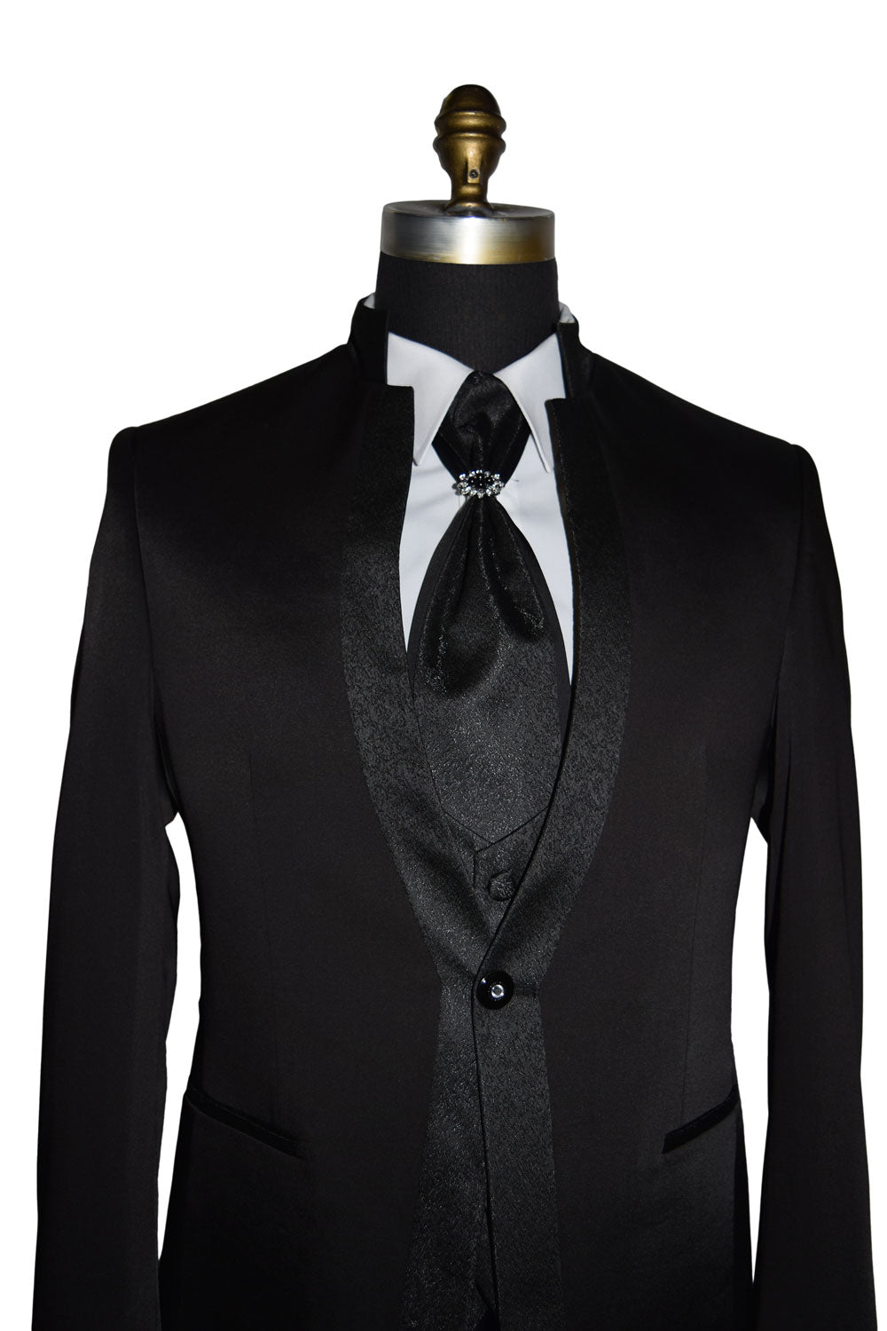 Black nehru tuxedo with a white shirt and black tie on a mannequin against a white background
