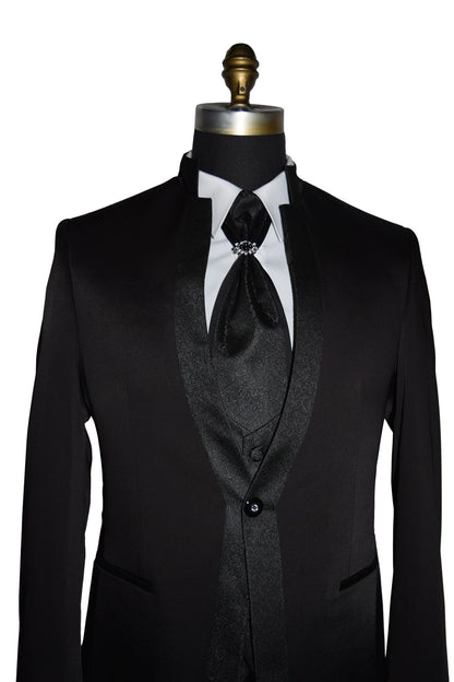 Black nehru tuxedo with a white shirt and black tie on a mannequin against a white background
