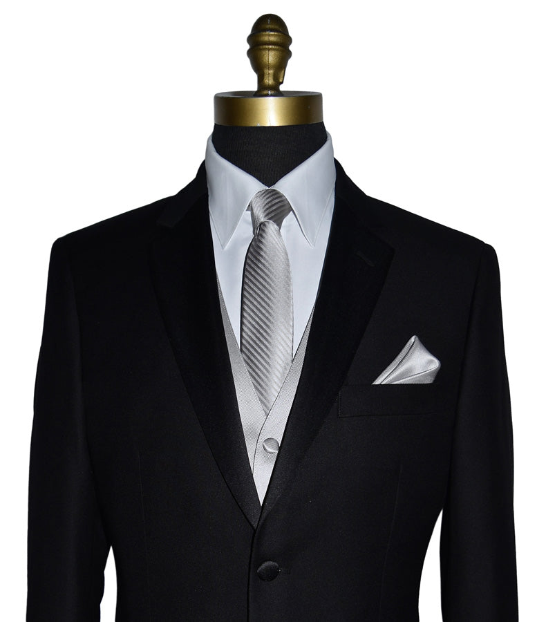 close-up mannequin wearing a black notch-lapel tuxedo and white dress shirt with a moonlight-gray tuxedo vest and a moonlight-gray striped necktie and moonlight pocket handkerchief against a white background