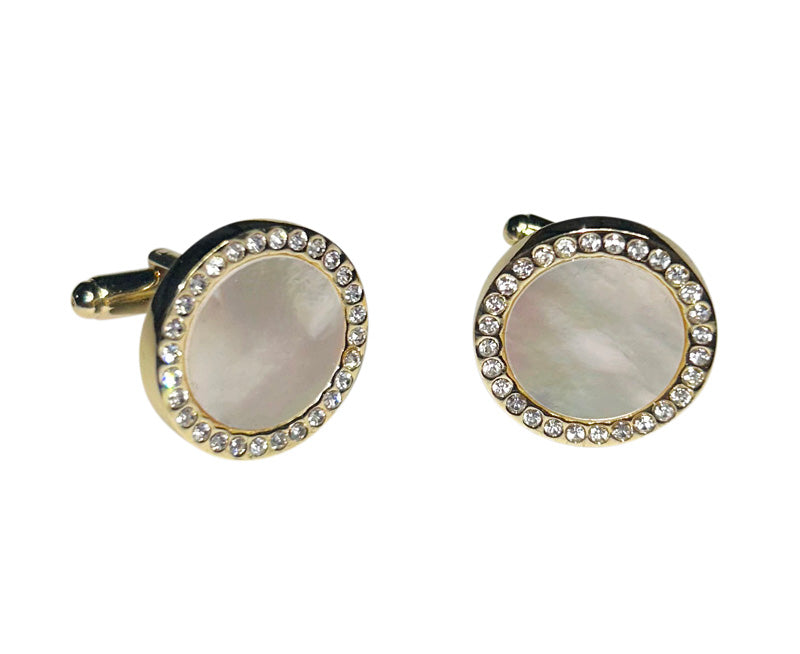close-up mother-of-pearl cufflinks with crystal and gold setting against a white background