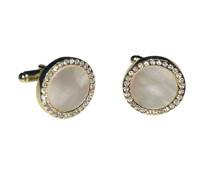 close-up mother-of-pearl cufflinks with crystal and gold setting against a white background