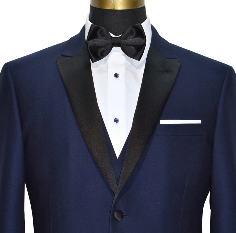 CLOSE-UP of a Navy blue 3 piece tuxedo with black lapels shown with a black satin "pre-tied" bowtie against a white background.