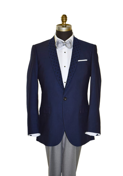 Navy blue tuxedo jacket with white dress shirt and gray pants on a mannequin against a white background