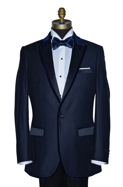 Navy blue tuxedo with navy blue velvet trim and a white shirt and bow tie on a mannequin against a white background
