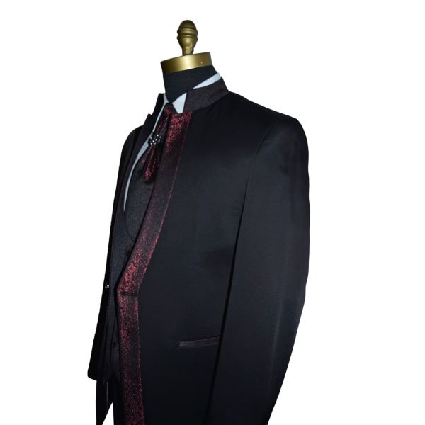 side view black nehru tuxedo ensemble with red accents on a mannequin against a white background
